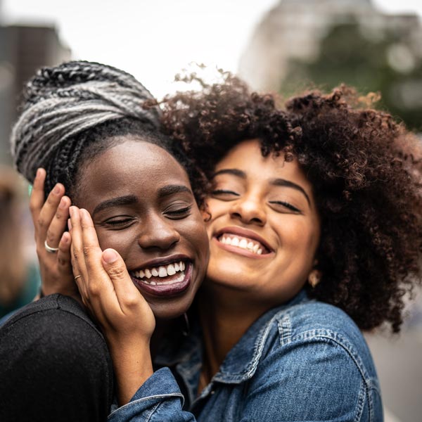 two friends hugging and smiling