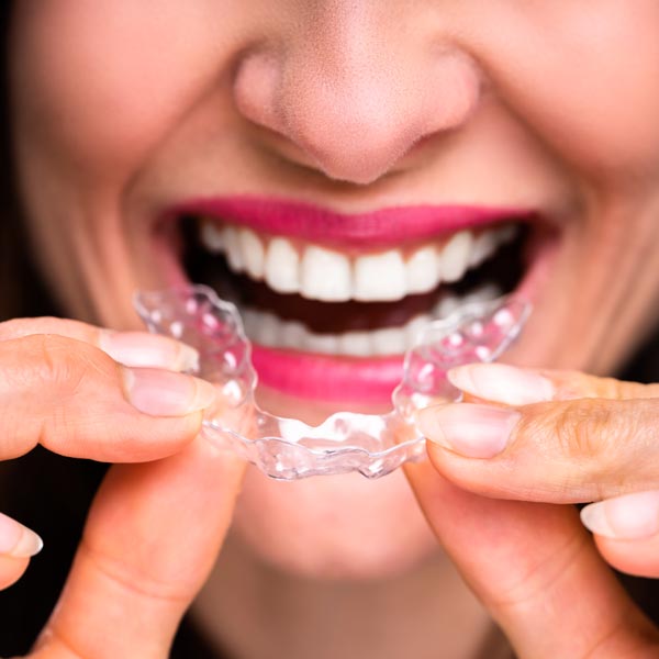 woman holding clear aligner